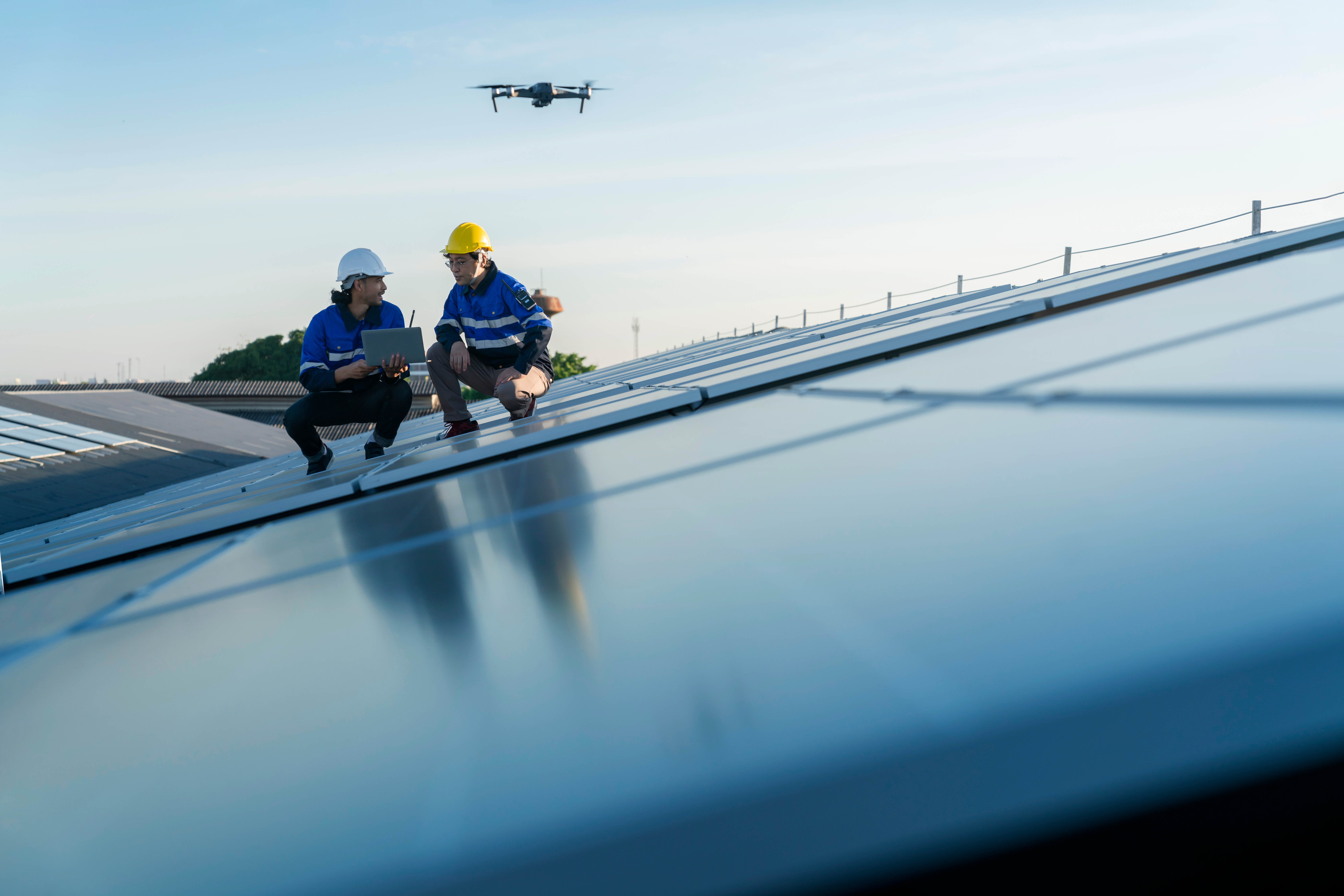 Technician inspecting solar panels, illustrating energy software development for efficient renewable energy management | DXC Technology
