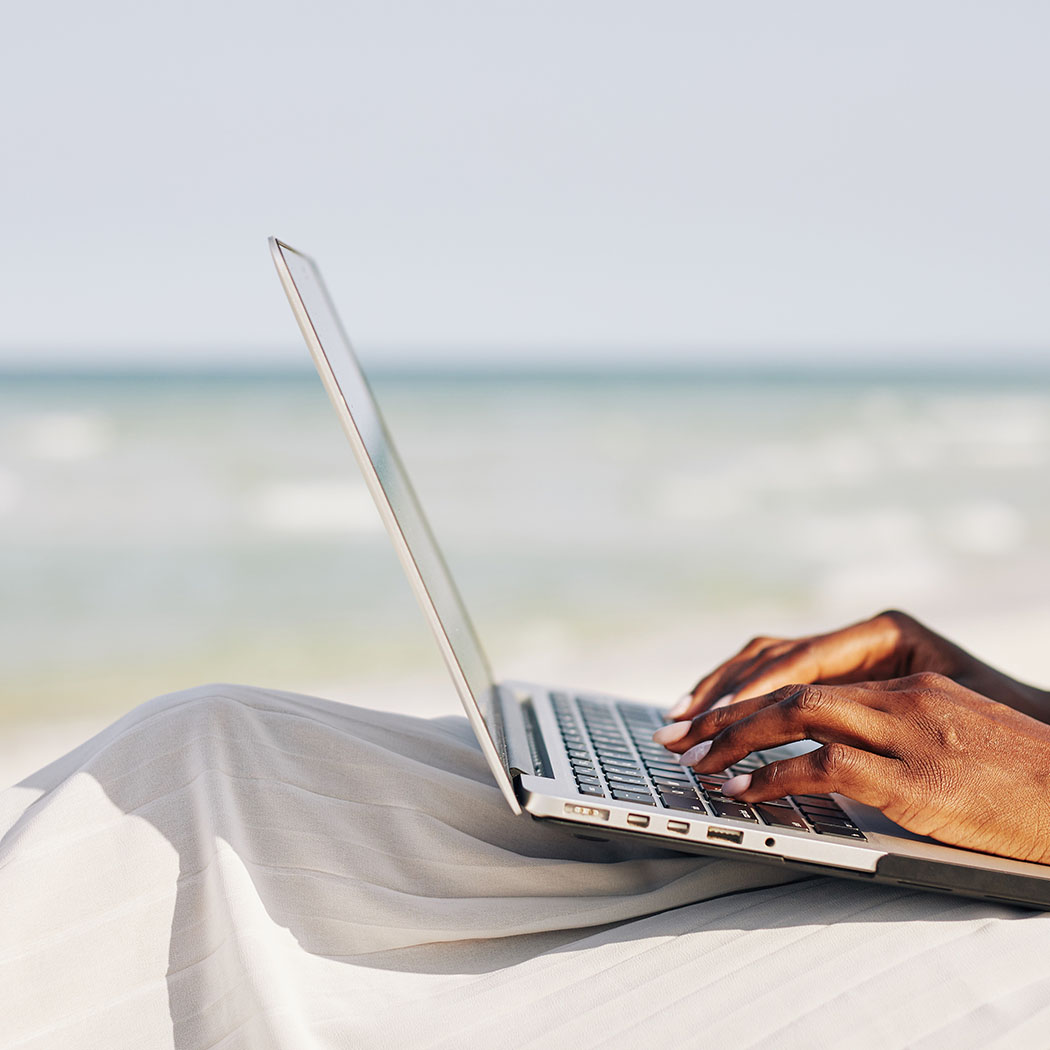 using a laptop on a beach