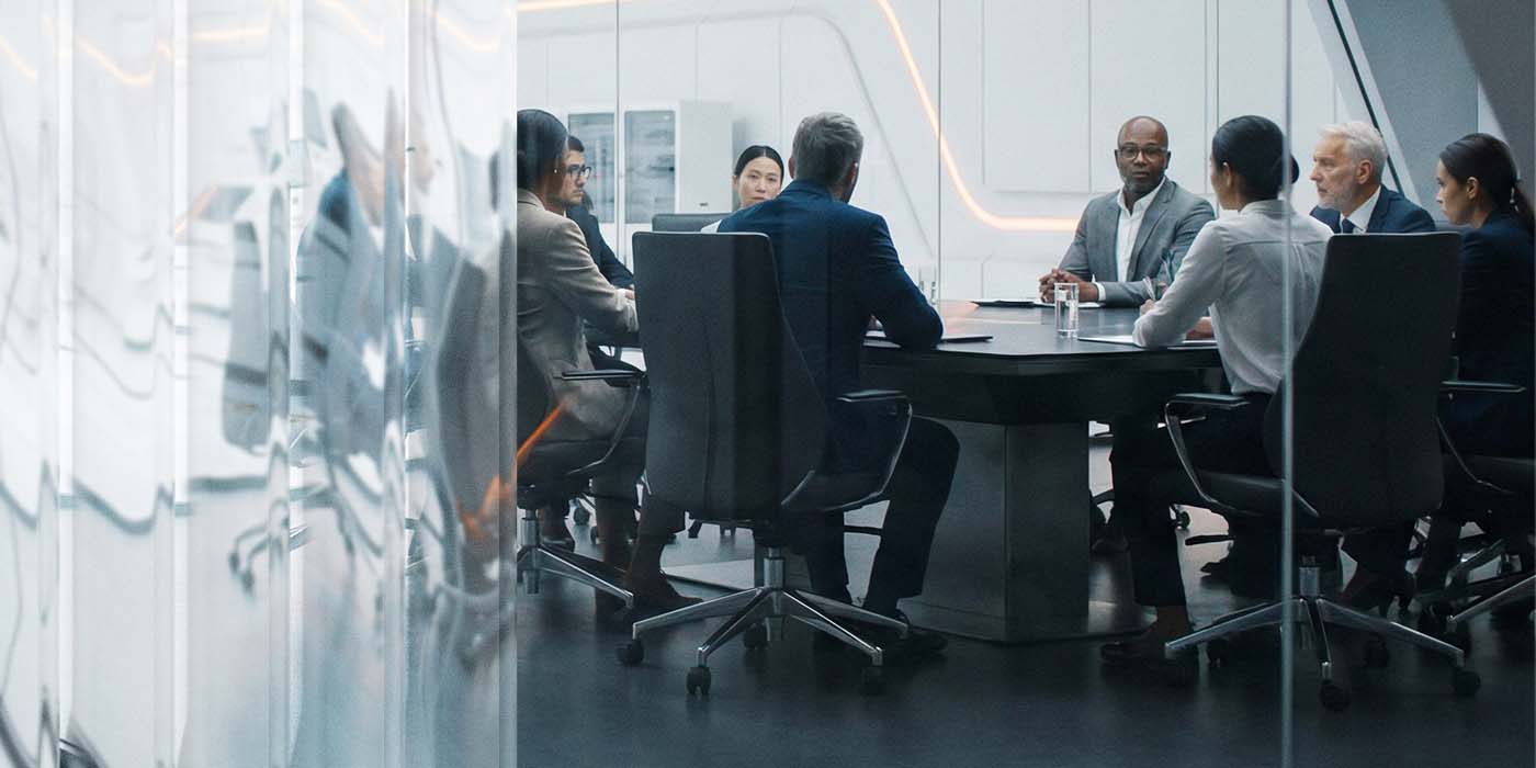 Business leaders meeting in modern corporate boardroom driving real results from SAP | DXC Technology Insights