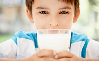 Boy holding glass of milk