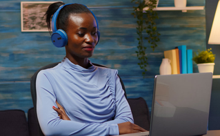 woman at laptop in home office using headphones