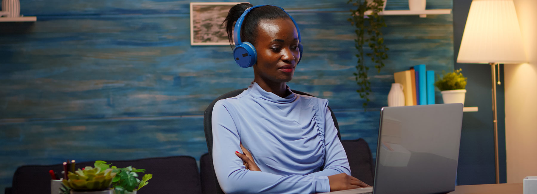 woman sitting at laptop with headphones, Modern Workplace | DXC Technology Insights