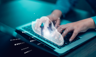 hands typing on keyboard with cloud image overlay, Mainframe Modernization | DXC Technology