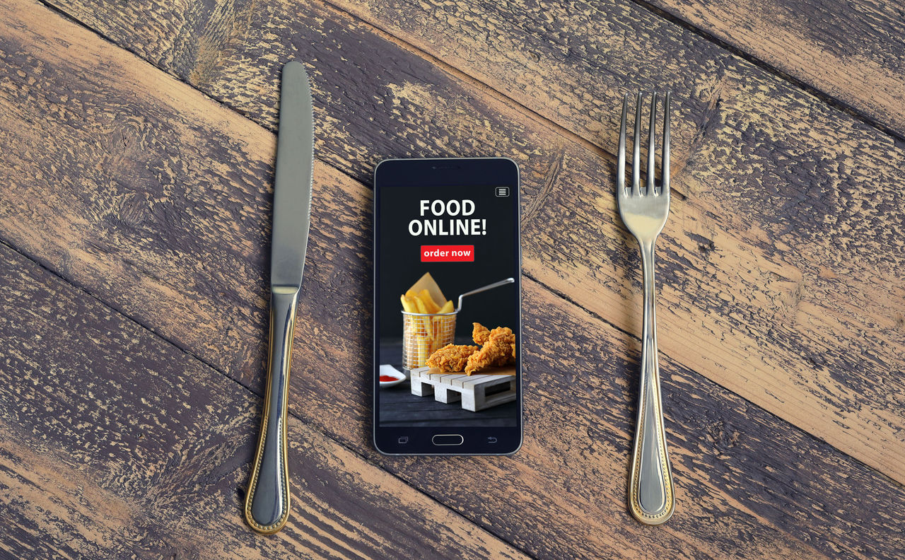 Mobile phone with order food online word on screen. Online food marketing concept. Blogging concept.