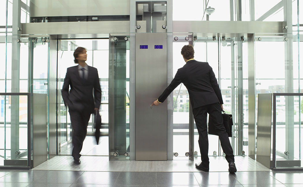 Businessmen arriving and leaving on elevators --- Image by © Juice Images/Corbis