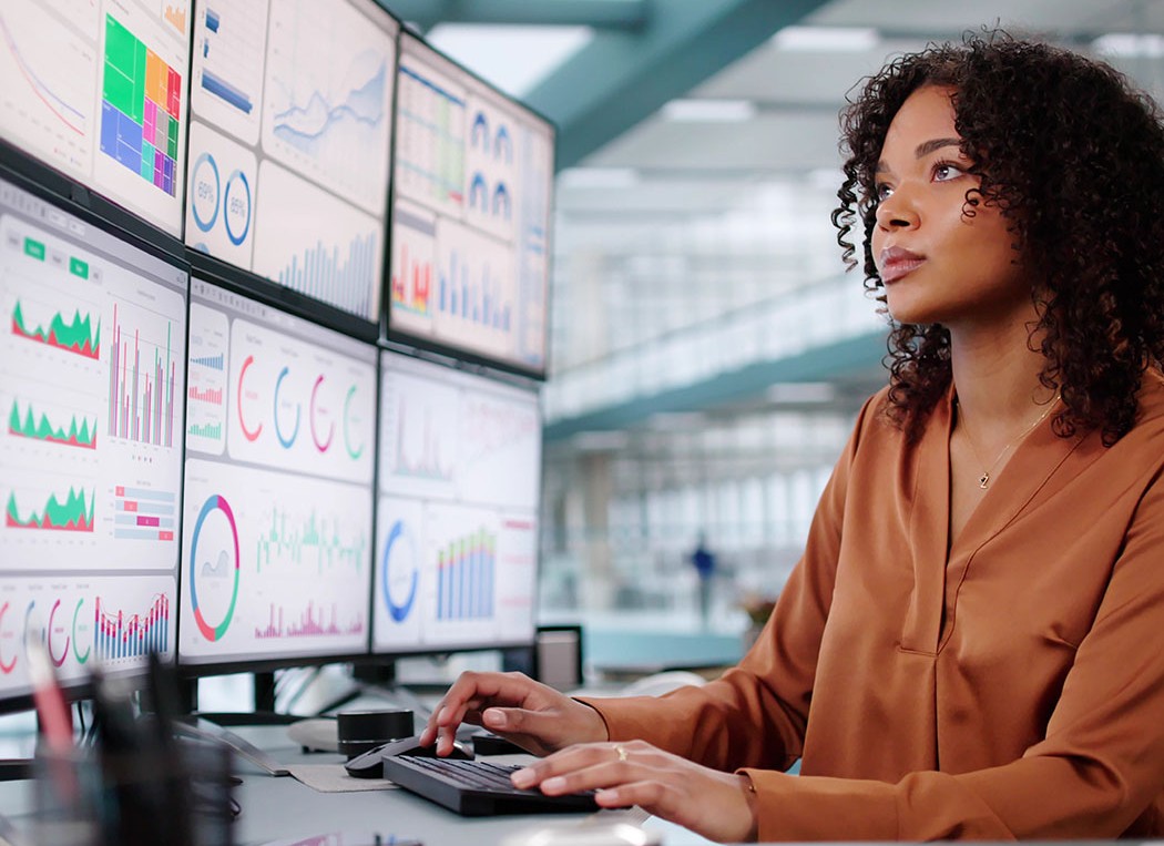 Female developer working in front of multiple screens, Trading Platform Health Check | DXC Technology