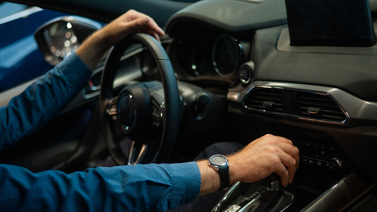 Close-up of a man's hand while shifting the automatic transmission of a car.