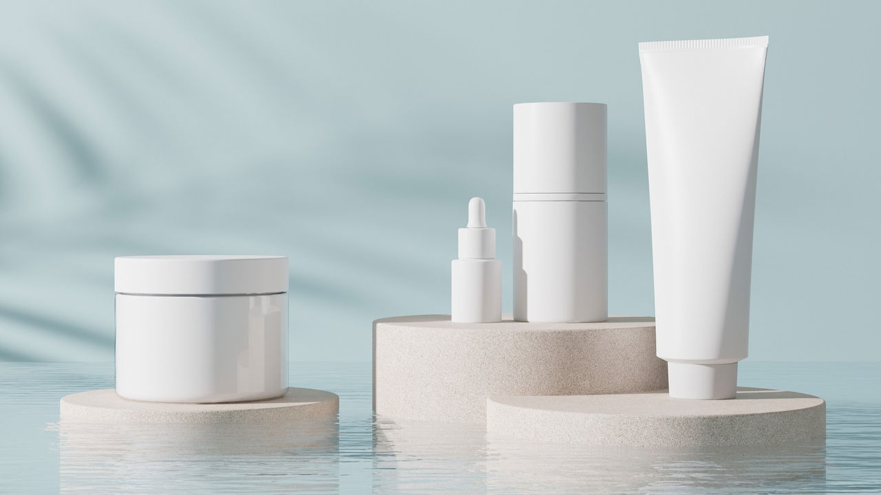 Group of white and blank, unbranded cosmetic cream jars and tubes on blue background. Skin care product presentation. Elegant mockup. Skincare, beauty and spa. Jar, tube with copy space. 3D rendering