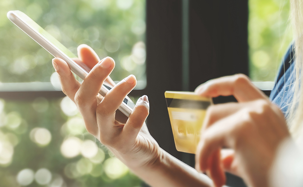 woman's hands with credit card and smartphone