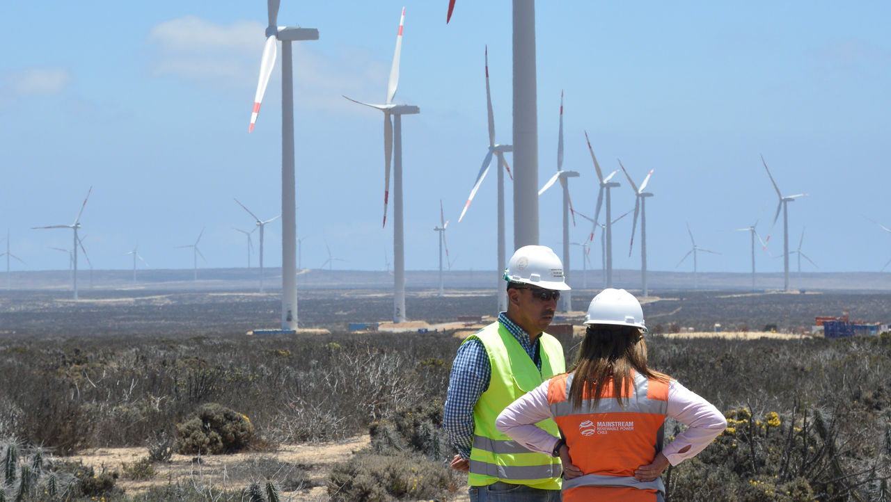 Energy workers standing in front of windmills, Public Cloud | DXC Technology Customer Story