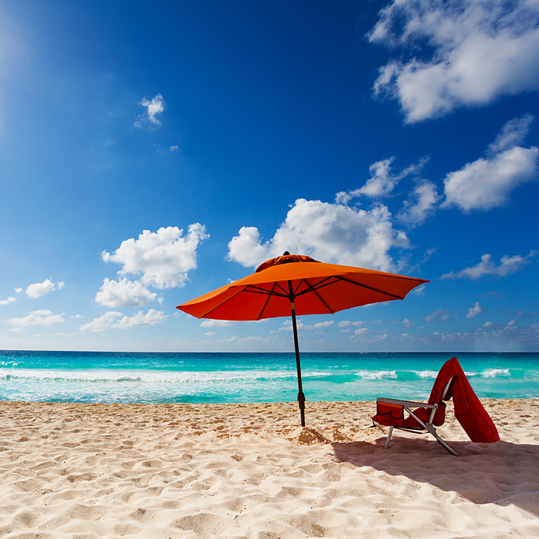 orange beach umbrella and chair at ocean edge, Cloud & Infrastructure | DXC Technology Insights