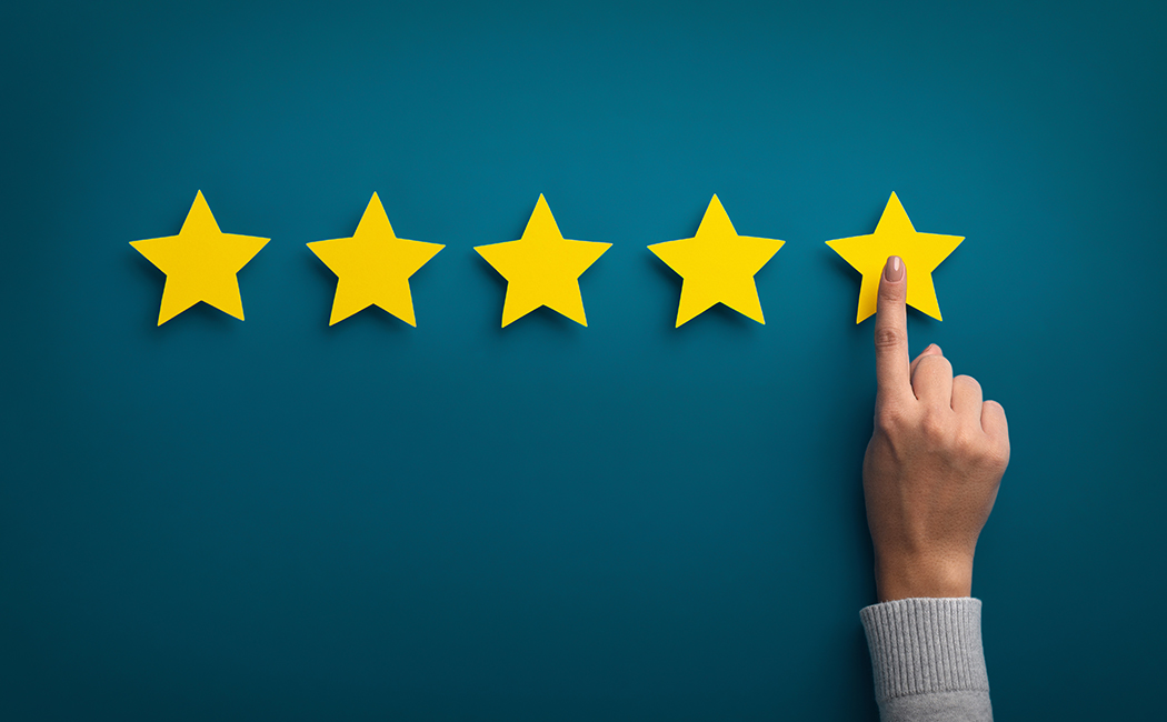 hand pointing to five gold stars, Insurance Software & BPS | DXC Technology